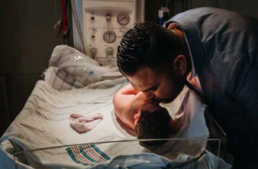 Father Kissing his son in a hospital nursary